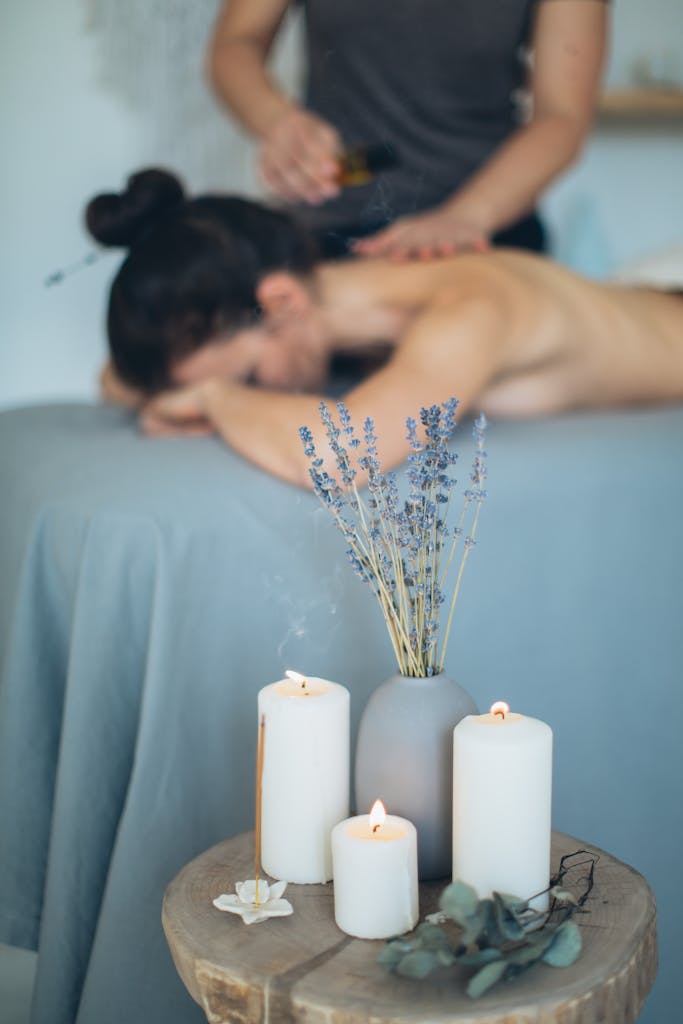 Scène de spa apaisante avec massage, lavande et bougies favorisant la relaxation.